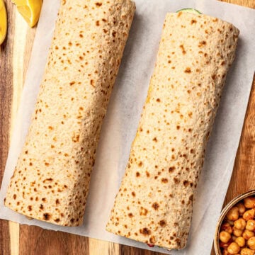 Two veggie wraps on parchment paper.