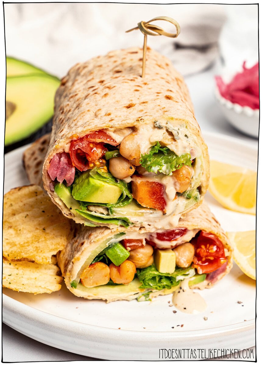 Made with simple ingredients in just 10 minutes, this crunchy hummus veggie wrap is perfect for lunch, meal prep, or an easy no-cook dinner! Stacked veggie wraps with hummus on plate.