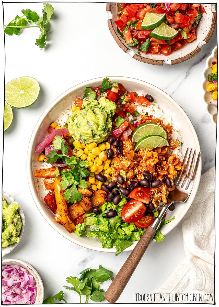 A guide to building your own burrito bowl with rice, protein, veggies, salsa, and creamy toppings for an easy and satisfying vegan meal. Overhead view of vegan burrito bowl with fork.