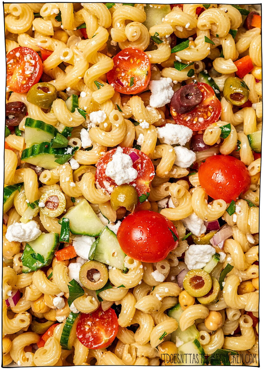 Bowl of pasta salad with text overlay that reads Mediterranean chickpea pasta salad. Overhead closeup of Mediterranean chickpea pasta salad.
