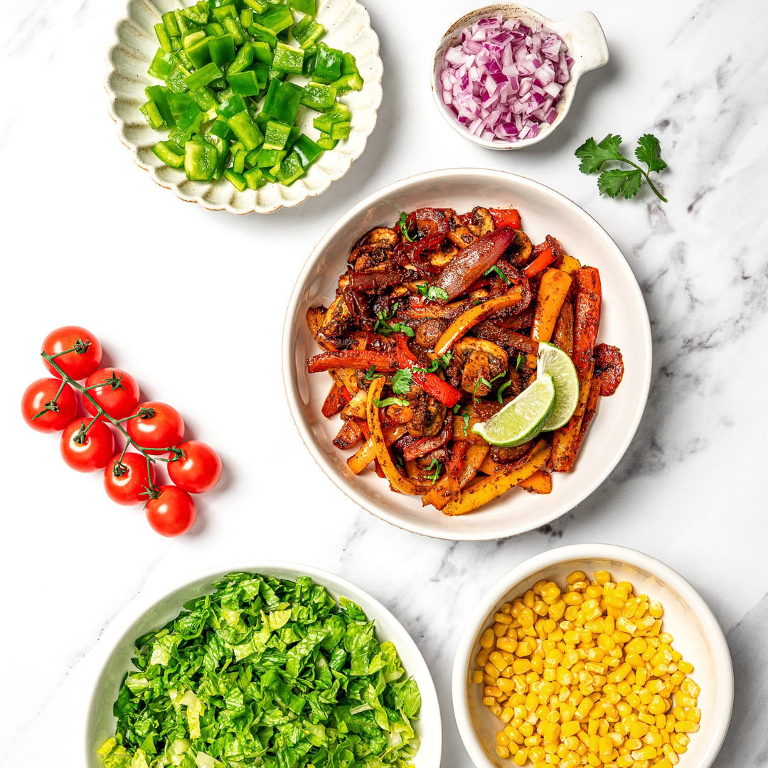 A guide to building your own burrito bowl with rice, protein, veggies, salsa, and creamy toppings for an easy and satisfying vegan meal.