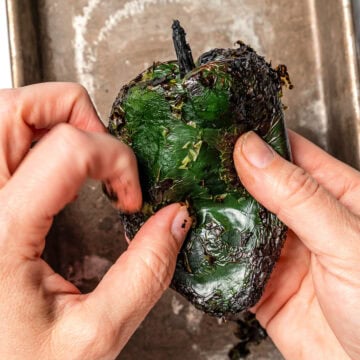 Peeling skin from poblano pepper.