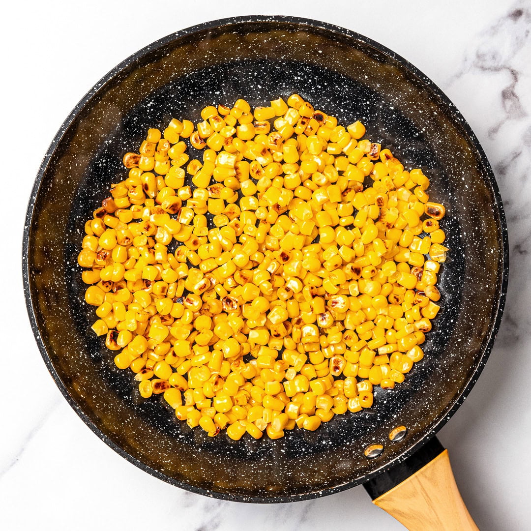 Made with charred corn, roasted poblano, cilantro, lime and red onion, this copycat Chipotle corn salsa is bright, smoky and so delicious! Charring corn in skillet.