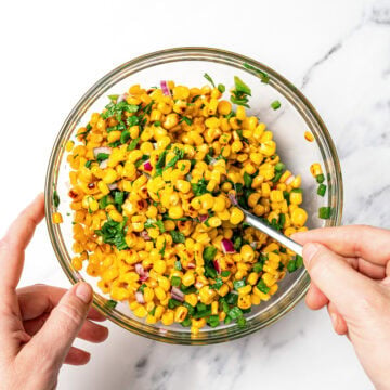 Stirring corn salsa in bowl.