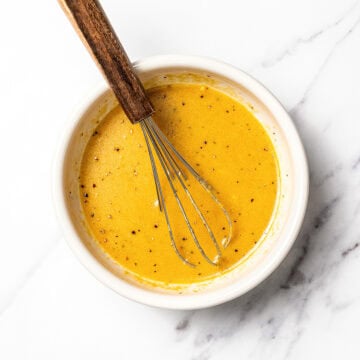 Lemon Dijon vinaigrette in bowl with whisk.