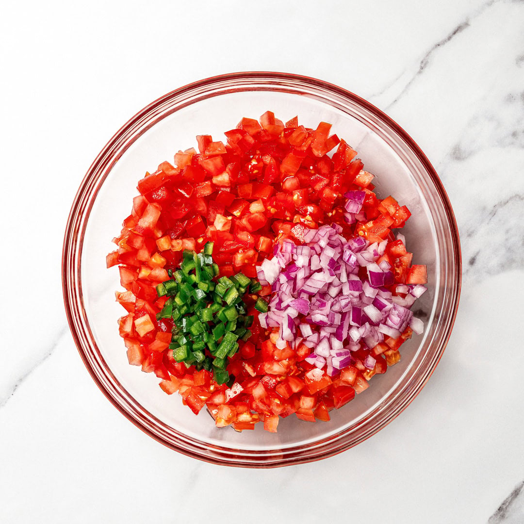 This pico de gallo tastes just like Chipotle's, but even better because it's extra fresh, easy to customize, and made at home in minutes! Diced tomato, jalapeno, and red onion in bowl.