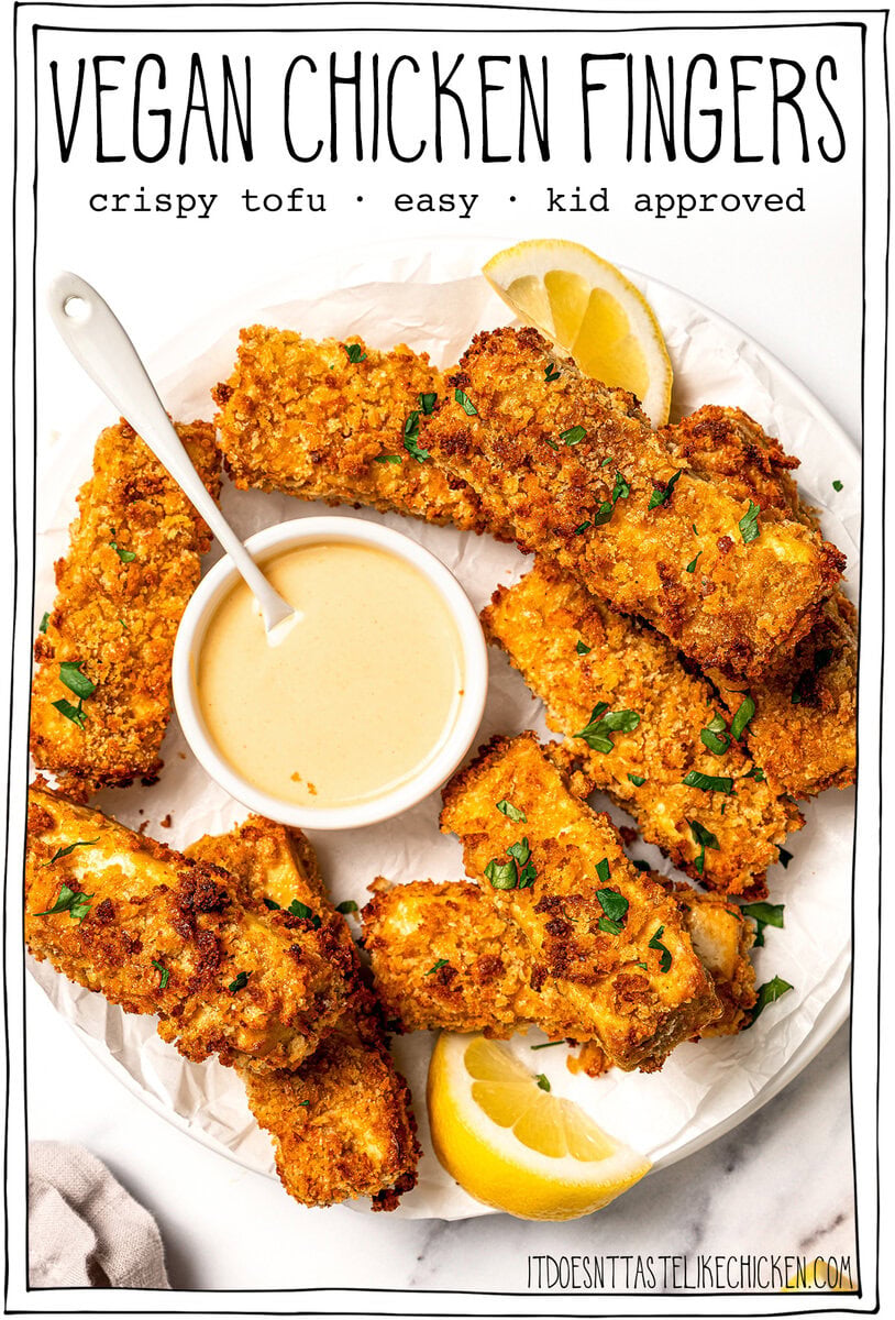 Plate of tofu chicken with sauce, with text overlay that reads vegan chicken fingers. Plate of tofu chicken with sauce, with text overlay that reads vegan chicken fingers.
