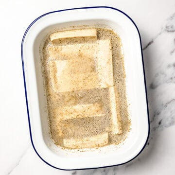 Tofu strips soaking in marinade.