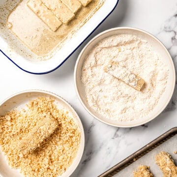 Tofu strips being coated in flour and panko.