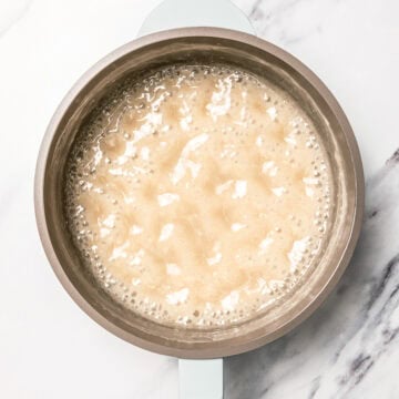 Vegan sweetened condensed milk simmering in pan.