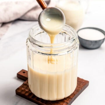 Spoon drizzling condensed milk into jar.