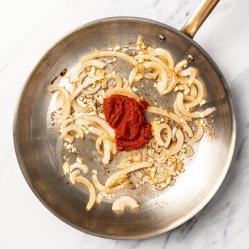 Curry paste and aromatics in skillet.