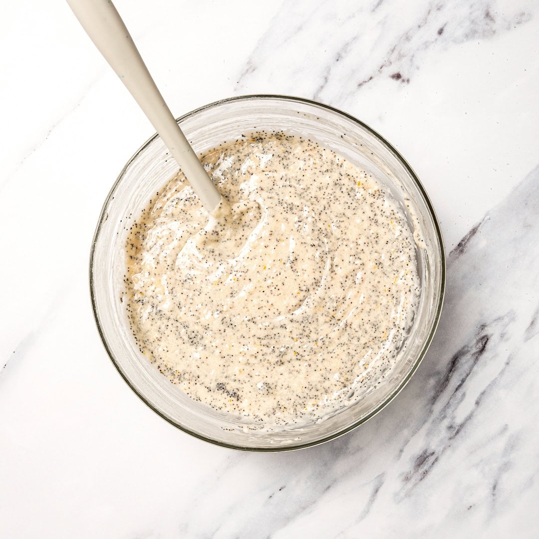 Lemon poppy seed muffin batter in bowl with spoon.