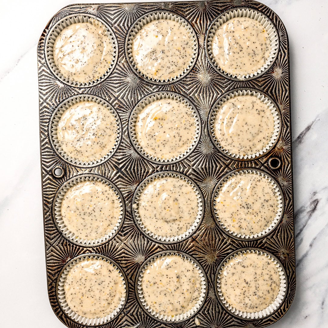 Unbaked vegan lemon poppy seed muffins in pan.