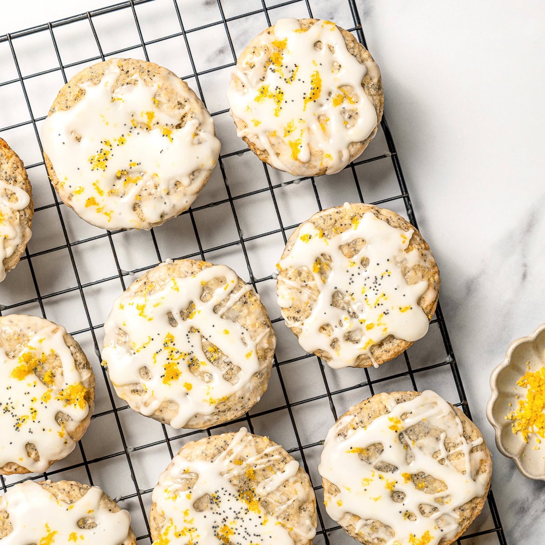 Glazed vegan lemon poppy seed muffins on wire rack.