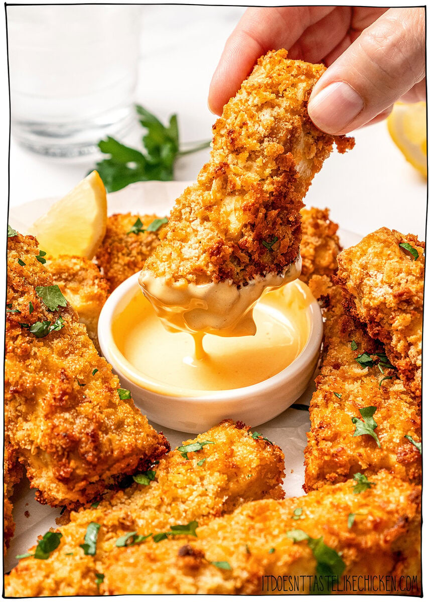 This homemade Vegan Honey Mustard Sauce is creamy, tangy, sweet, and ready in just 5 minutes, perfect for dipping ALL the things! Dipping crispy tofu into bowl of vegan honey mustard sauce.