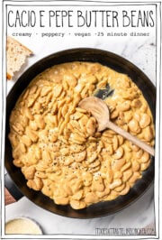 Skillet of beans with text overlay that reads cacio e pepe butter beans.