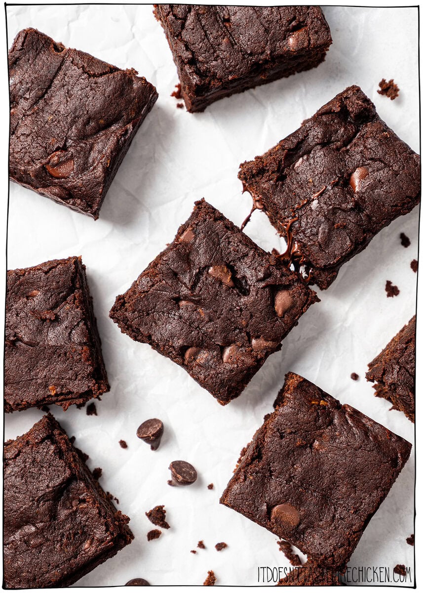 These vegan Sweet Potato Brownies are rich, fudgy, and loaded with deep chocolate flavor. You'd never know they're made with sweet potatoes! Sweet potato brownies on parchment paper.