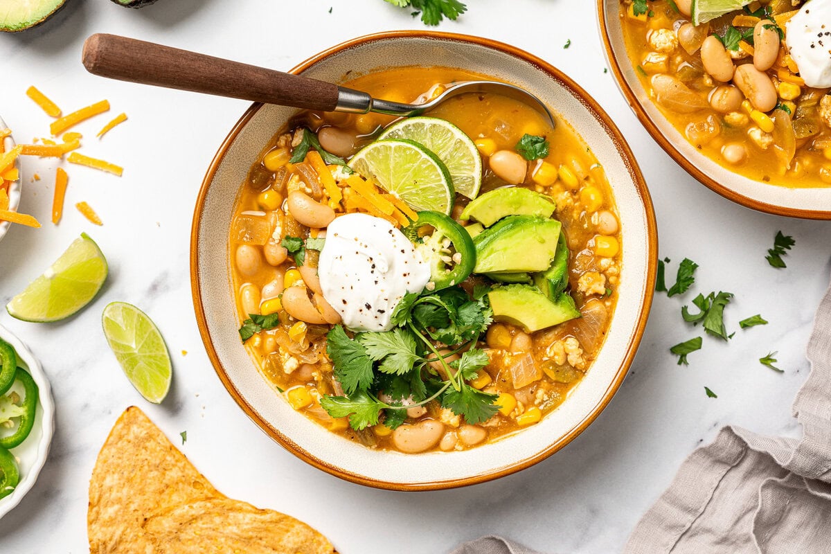 This easy Vegan White Bean Chili is creamy, hearty, and packed with cozy Southwestern-inspired flavors. Tofu adds a satisfying, meaty bite! Bowl of vegan white bean chili with toppings.