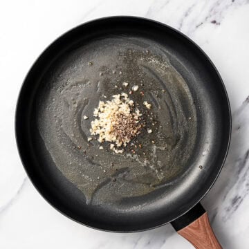 Garlic and black pepper in skillet.