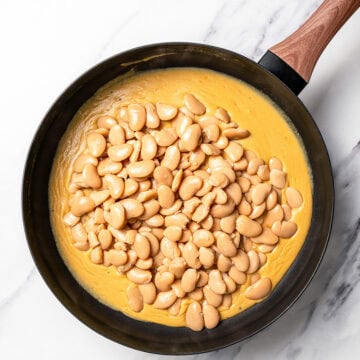 Butter beans added to vegan cacio e pepe sauce.