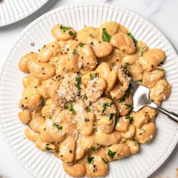 Plate of cacio e pepe butter beans with fork.
