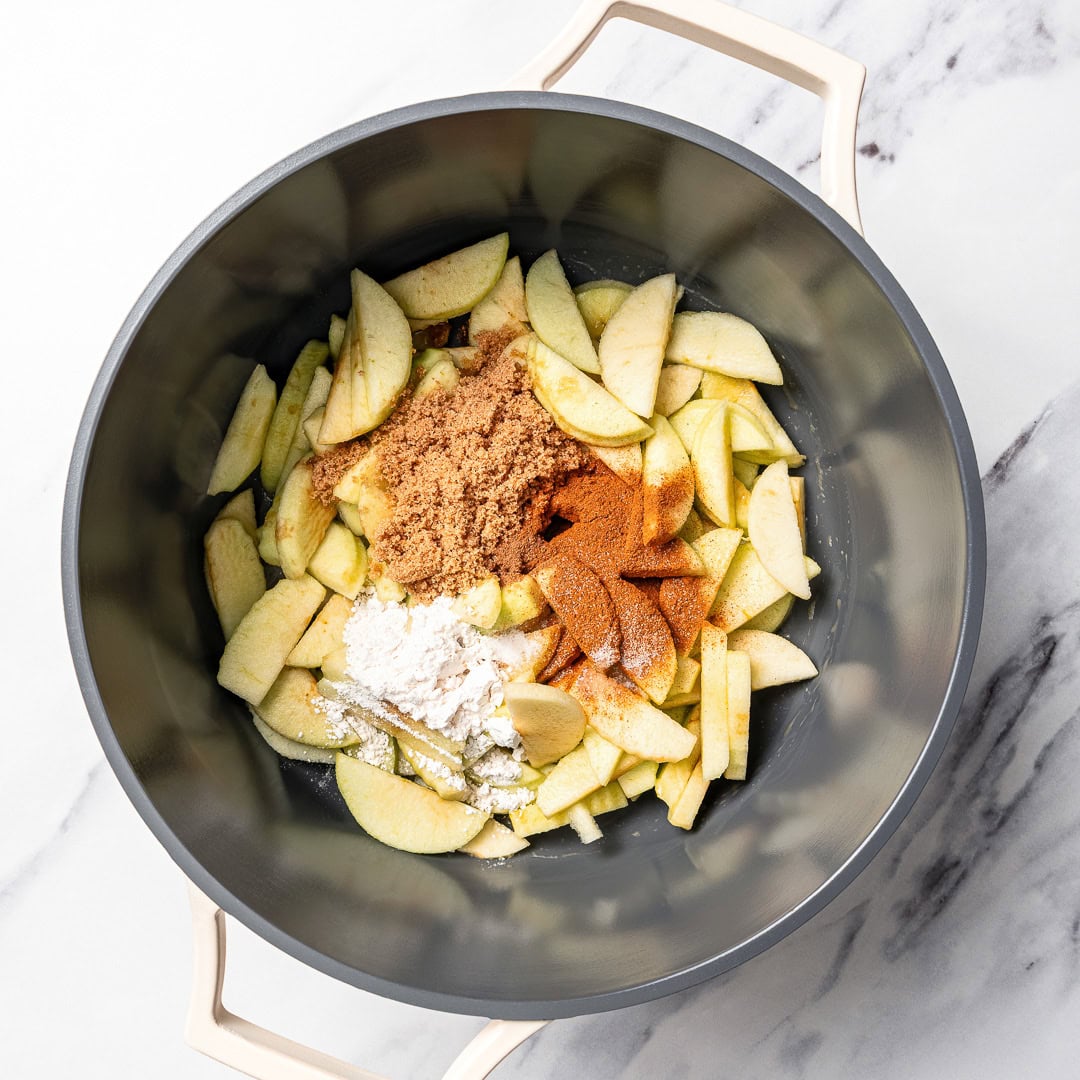 This Easy Vegan Apple Cobbler pairs tender spiced apples with a soft, buttery cake-like topping swirled with cinnamon sugar. So delicious! Ingredients for apple cobbler filling in pot.