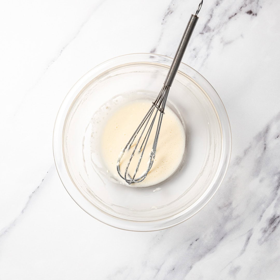 Whisk in bowl of vegan cream cheese glaze.
