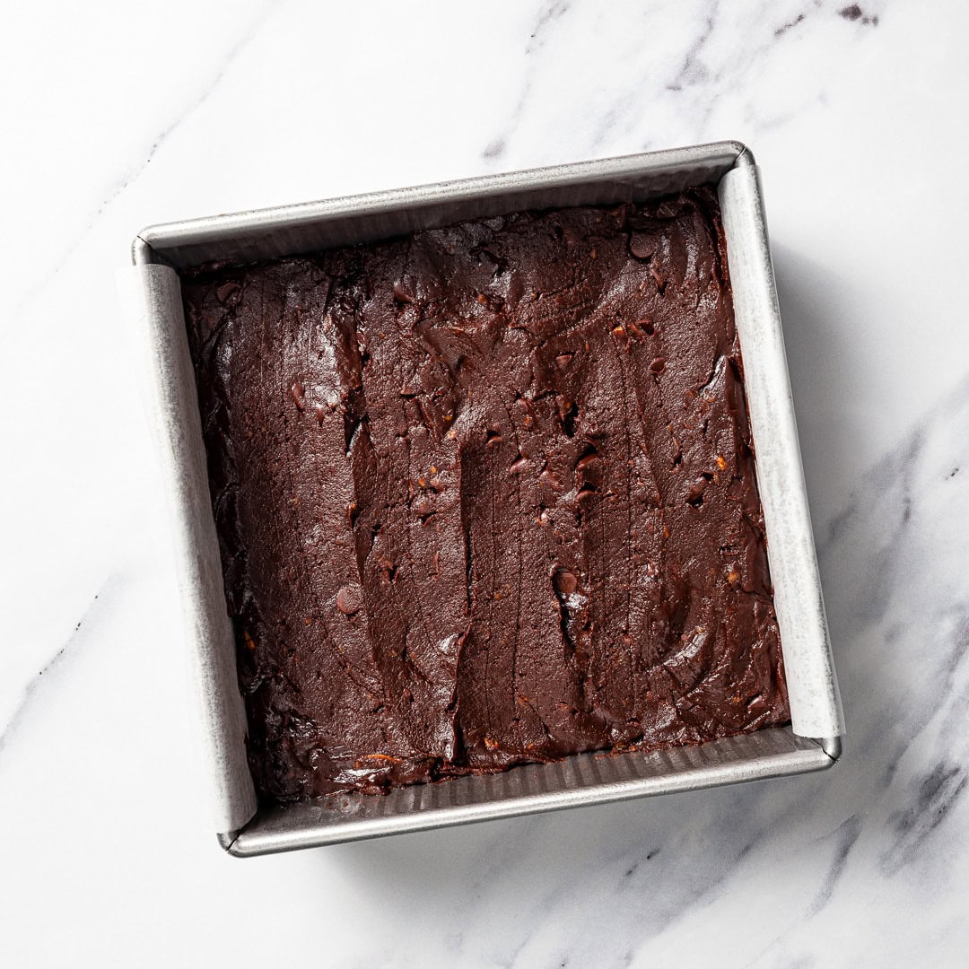 These vegan Sweet Potato Brownies are rich, fudgy, and loaded with deep chocolate flavor. You'd never know they're made with sweet potatoes! Vegan sweet potato brownie batter spread in pan.