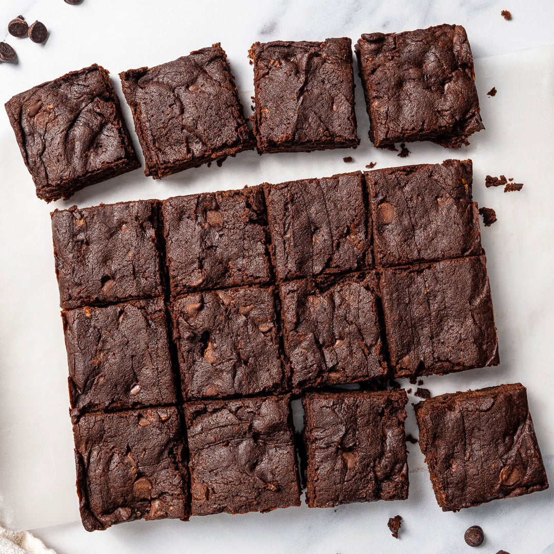 These vegan Sweet Potato Brownies are rich, fudgy, and loaded with deep chocolate flavor. You'd never know they're made with sweet potatoes! Sweet potato brownies cut into squares.