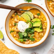 Bowl of vegan white bean chili with toppings.